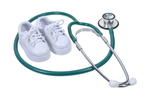 Stethoscoop en kleine witte schoenen — Stockfoto