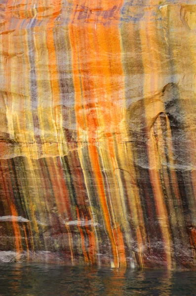 Farbenfrohe Streifen auf Klippen an abgebildeten Felsen am nationalen Seeufer — Stockfoto