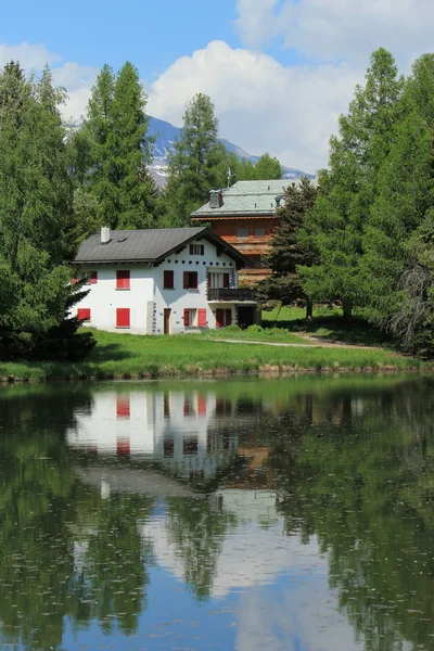 Casa e lago branco em Crans Montana, por verão — Fotografia de Stock