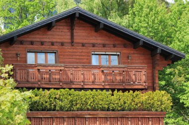 Wooden chalet among summer trees clipart