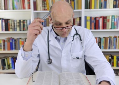 Doctor looking up information on medicine clipart