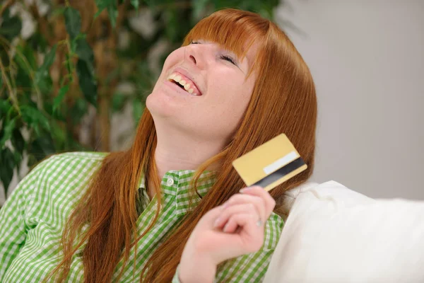 Молодая женщина со смехом по кредитке — стоковое фото