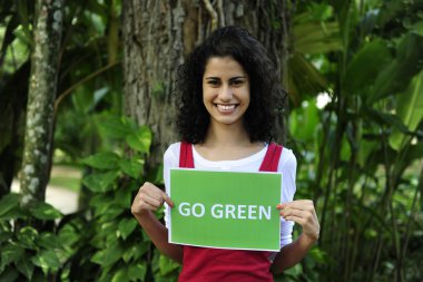 Environment conservation: woman in the forest holding a go green sign clipart