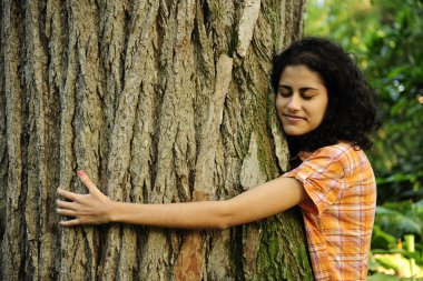 Doğa aşık: kadın ormanda bir ağaç sarılma