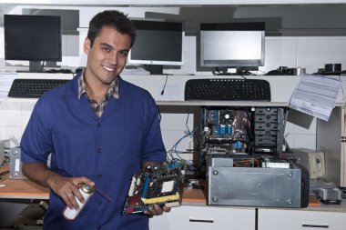 Computer technician with motherboard at workshop clipart