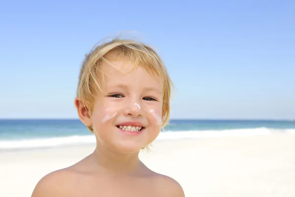 Lindo niño con protector solar en la playa —  Fotos de Stock