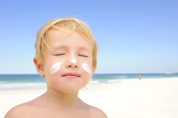 Plajda güneş koruyucu ile şirin çocuk — Stok fotoğraf
