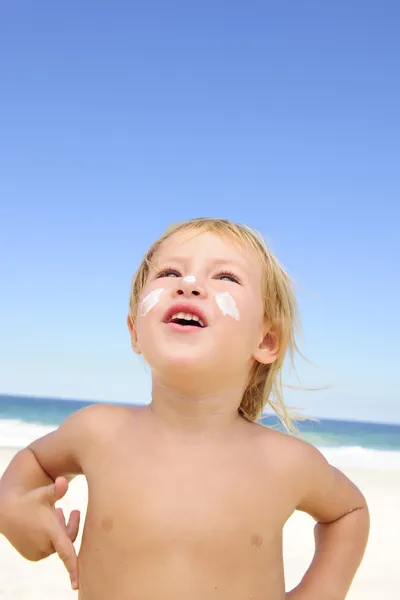Aranyos gyermek, és fényvédő a strandon — Stock Fotó