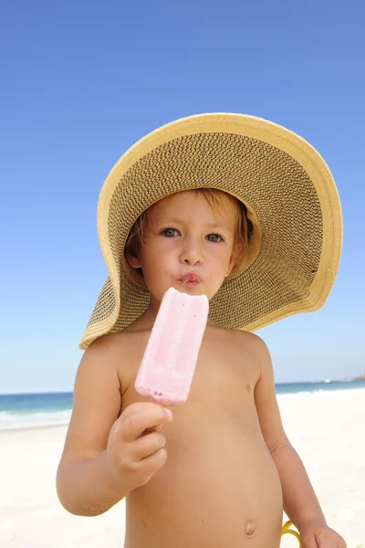Letní prázdniny: dítě jíst zmrzlinu na pláži — Stock fotografie