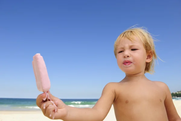 Summer vacation: child eating icecream on the beach — Stock Photo, Image