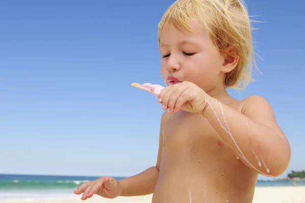 Summer vacation: child eating icecream on the beach — Stock Photo, Image