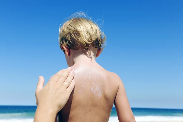 Mother applying sunscreen on childs back — Stock Photo, Image