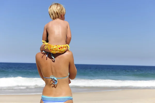Madre che porta sua figlia sulle spalle sulla spiaggia — Foto Stock