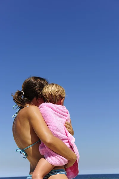 Mãe carregando sua filha na praia — Fotografia de Stock