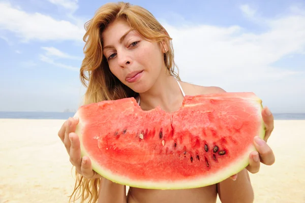 Frau isst Wassermelone am Strand — Stockfoto