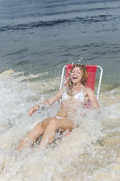 Instantánea: mujer en la playa sorprendida por las olas del océano —  Fotos de Stock