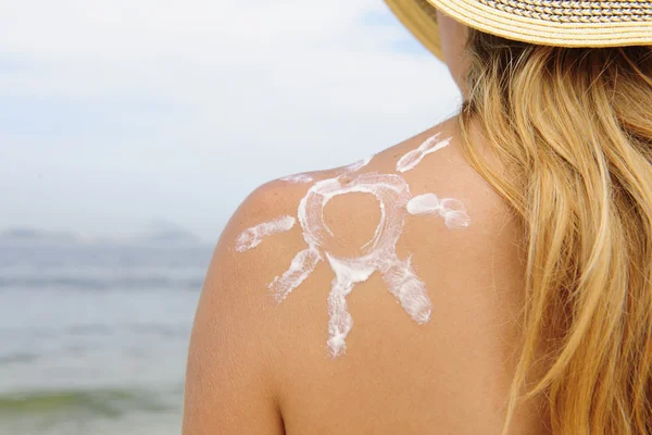 Vrouw met zonnecrème op het strand — Stockfoto