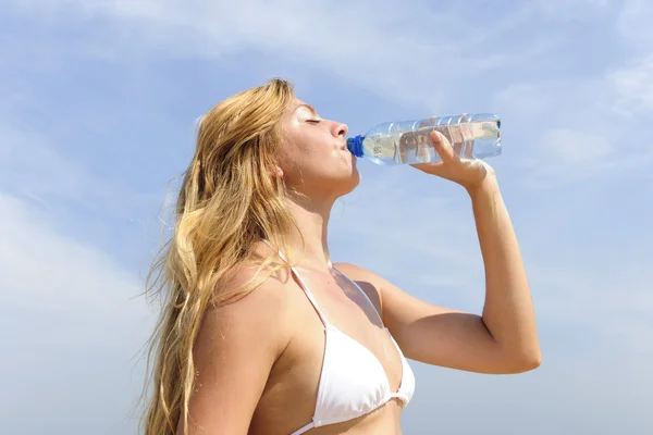 Жага жінка п'є воду на відкритому повітрі в літній день — стокове фото
