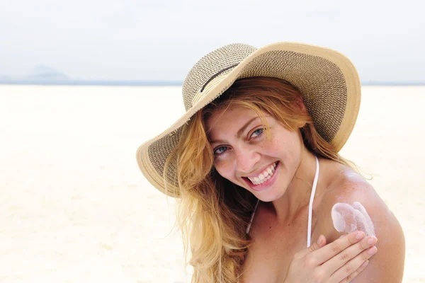 Жінка застосовує соляний лосьйон на пляжі — стокове фото