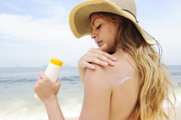 Žena použití opalovací krém na pláži — Stock fotografie