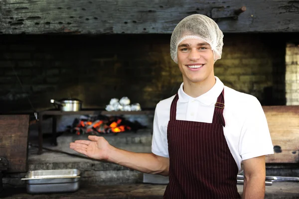 Человек, работающий в ресторане, показывает дровяную печь — стоковое фото