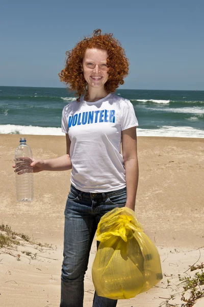 Dobrovolník sbírání odpadků na pláži — Stock fotografie
