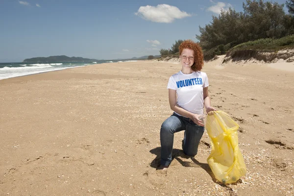 Voluntário coletando lixo na praia — Fotografia de Stock