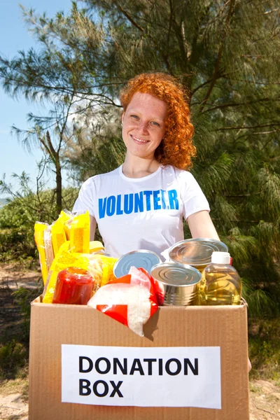 Voluntario llevando caja de donación de alimentos — Foto de Stock
