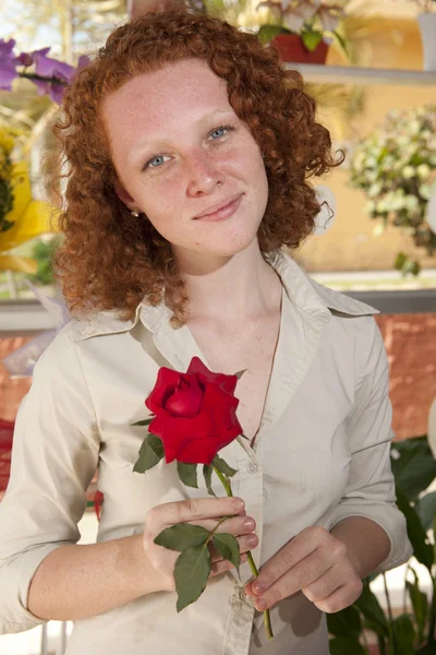 Žena držící jedinou růži — Stock fotografie