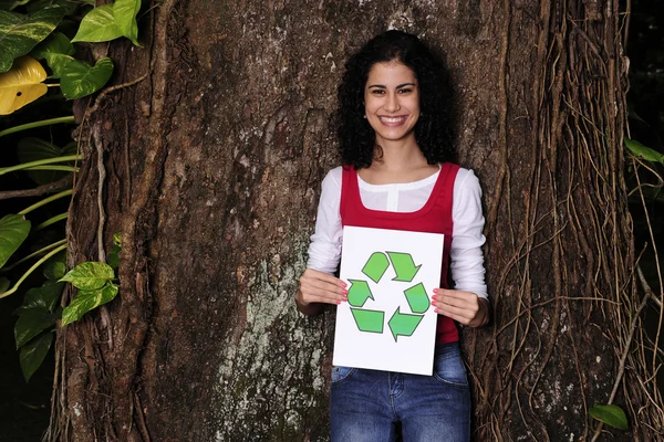 Recyclage : une femme dans la forêt tenant un panneau de recyclage — Photo