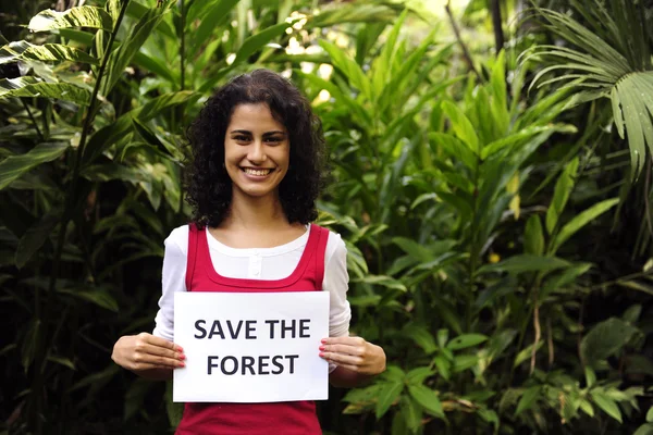 Охрана окружающей среды: женщина держит знак сохранения леса — стоковое фото