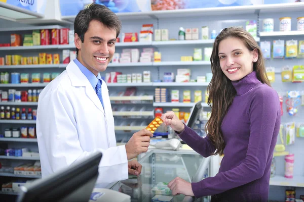 Apotheker en klant bij de apotheek — Stockfoto