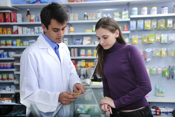 Farmacêutico que aconselha o cliente na farmácia — Fotografia de Stock