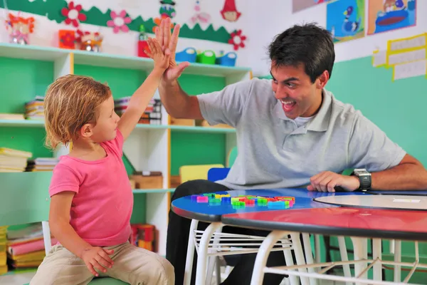 Maestro de preescolar y niño dando choca esos cinco — Foto de Stock