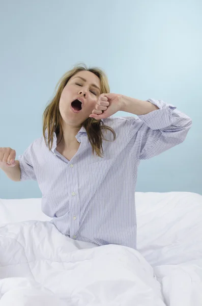 Mujer bostezando en la cama — Foto de Stock