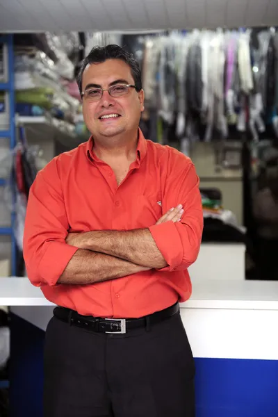 Happy owner of a dry cleaning business — Stock Photo, Image