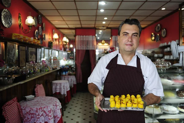 Pequeña empresa: propietario de un café que muestra pastelería sabrosa — Foto de Stock