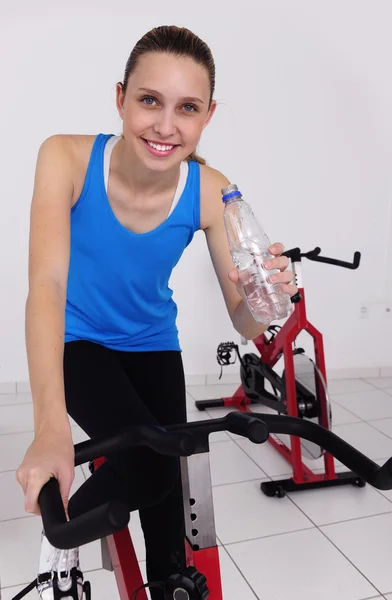 Vrouw fietsen op de sportschool — Stockfoto