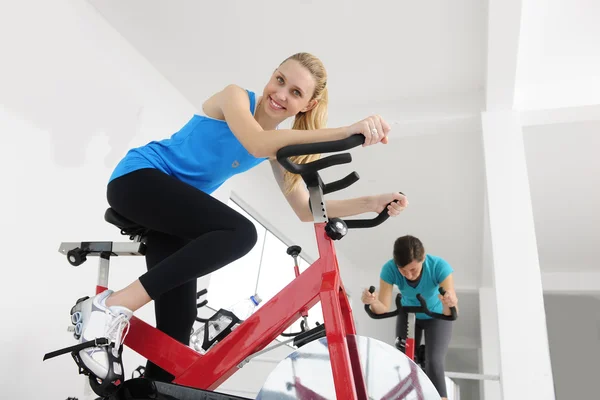 旋转。在健身房骑自行车的女人 — 图库照片