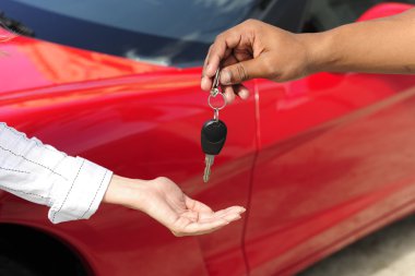Woman receiving car key from salesman clipart