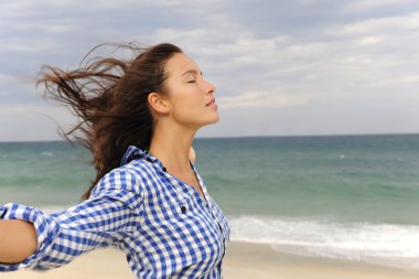 Woman enjoying the wind and the sea clipart