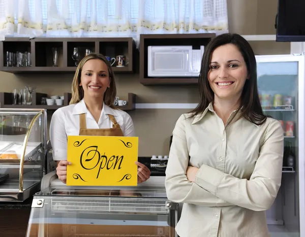 Happy owner of a cafe showing open sign — Stock Photo, Image