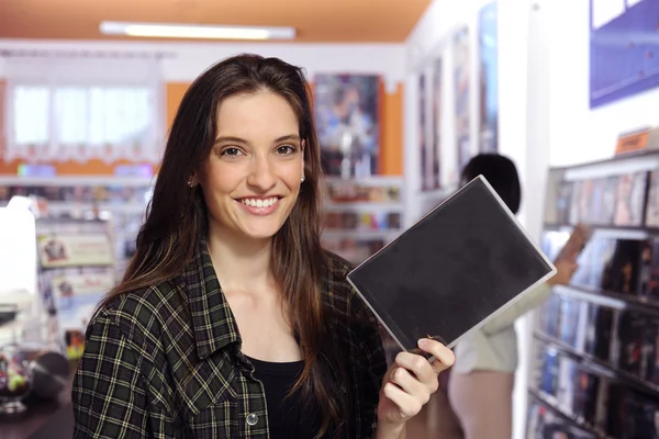 Счастливая женщина в магазине видеопроката — стоковое фото