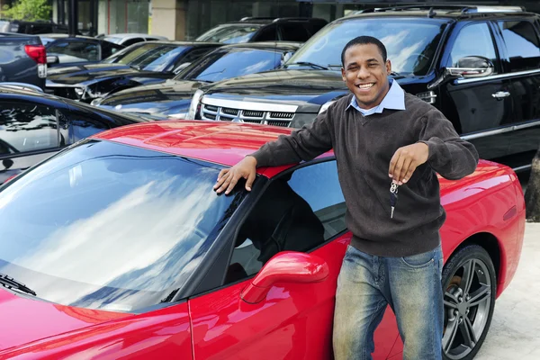 Hombre mostrando la llave del nuevo coche deportivo rojo — Foto de Stock