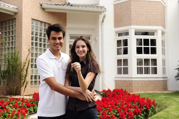 Happy homeowners infront of new house — Stock Photo, Image