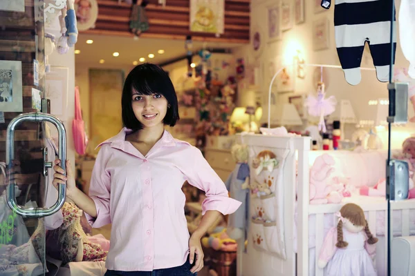 Propietario de una pequeña empresa: mujer orgullosa abriendo su tienda de bebés —  Fotos de Stock