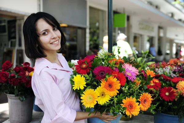 Женщина с огромным букетом цветов на открытом воздухе — стоковое фото