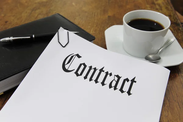 Contract en koffie op een bureau — Stockfoto