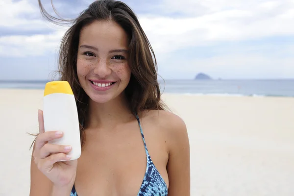 Donna che mostra crema solare in spiaggia — Foto Stock