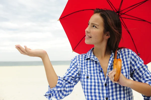 Mujer con paraguas rojo tocando la lluvia — Foto de Stock